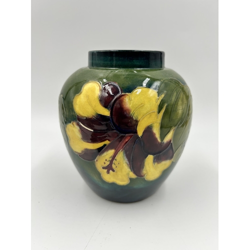 301 - A Moorcroft Hibiscus pattern ginger jar and cover - approx. 15cm high