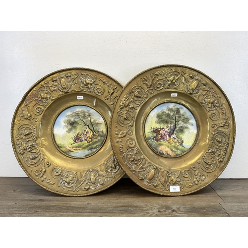 411 - Two late 19th/early 20th century embossed brass chargers with hand decorated enamel inserts - approx... 