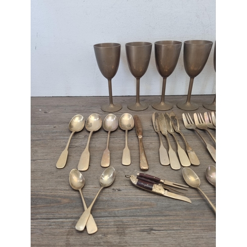 423 - A collection of brassware to include set of six wine goblets, cutlery etc.