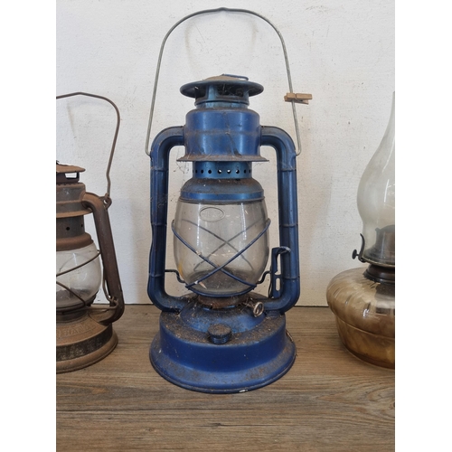 432 - Four paraffin lamps and lanterns to include Dietz No.90, Feuer Hand No. 1275 etc.