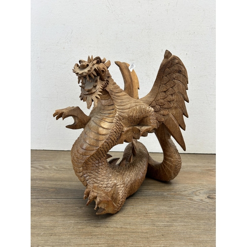 523 - A carved suar wood dragon statue - approx. 28cm high