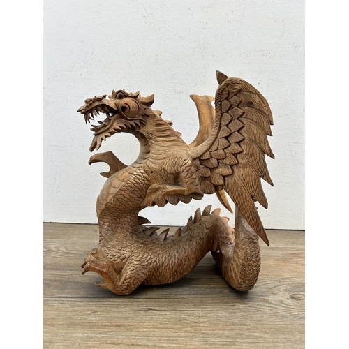 523 - A carved suar wood dragon statue - approx. 28cm high