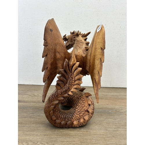 523 - A carved suar wood dragon statue - approx. 28cm high