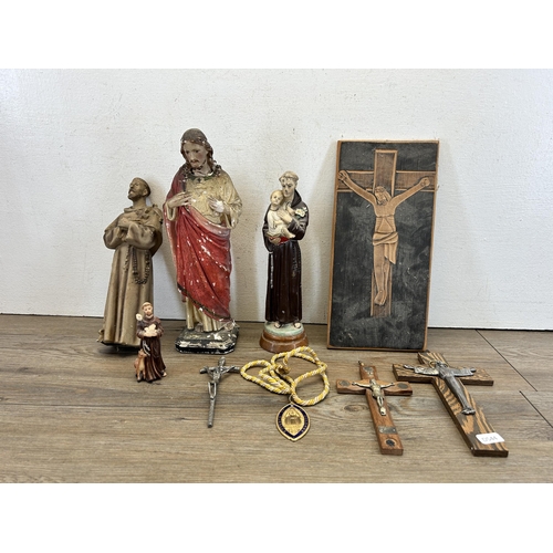 527 - A collection of religious artifacts to include chalkware Jesus figurine, carved oak panel of crucifi... 