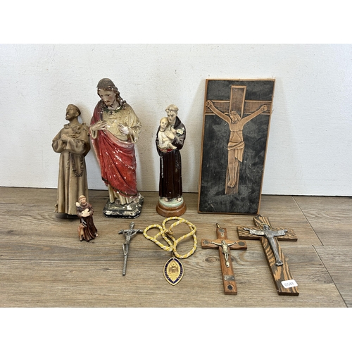 527 - A collection of religious artifacts to include chalkware Jesus figurine, carved oak panel of crucifi... 