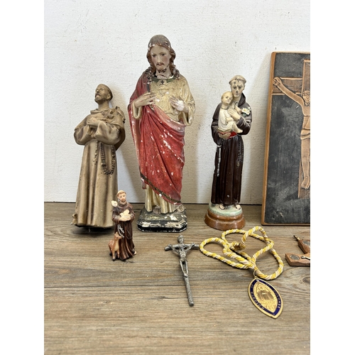 527 - A collection of religious artifacts to include chalkware Jesus figurine, carved oak panel of crucifi... 