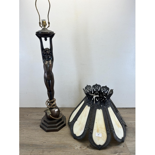 545 - A bronze effect figural table lamp with Tiffany style cast metal and stained glass shade