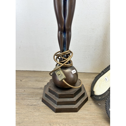 545 - A bronze effect figural table lamp with Tiffany style cast metal and stained glass shade