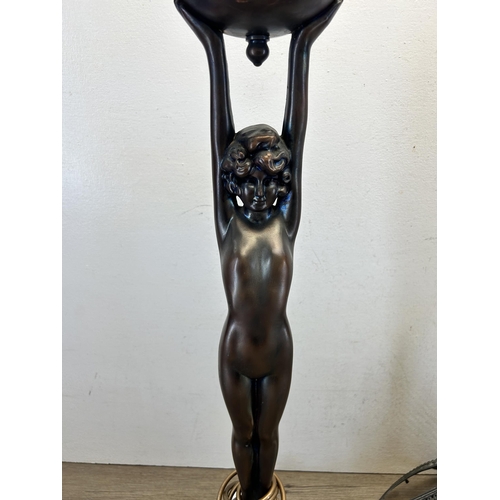 545 - A bronze effect figural table lamp with Tiffany style cast metal and stained glass shade