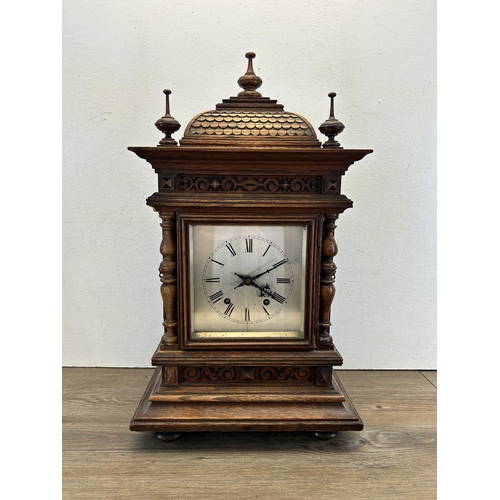 553 - An early 20th century W & H In Sch heavily carved oak cased chiming mantel clock with key and pendul... 