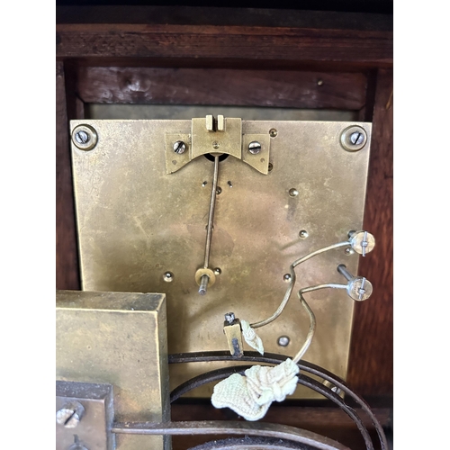 553 - An early 20th century W & H In Sch heavily carved oak cased chiming mantel clock with key and pendul... 