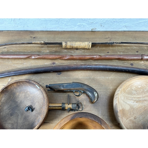 559 - A collection of items to include replica percussion pistol, carved teak tribal walking stick, bamboo... 