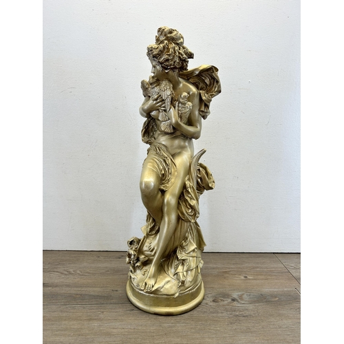 561 - A Neoclassical style gilt figurine of a nude lady holding a pair of birds with artist's signature to... 