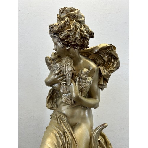 561 - A Neoclassical style gilt figurine of a nude lady holding a pair of birds with artist's signature to... 