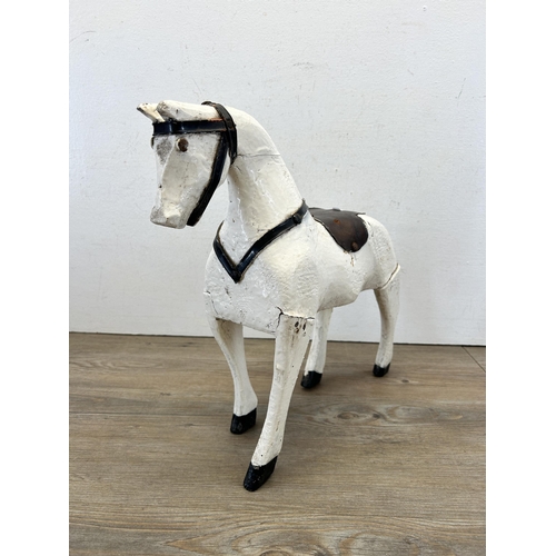 562 - An early 20th century white and black painted hardwood horse figurine - approx. 36cm high x 40cm lon... 