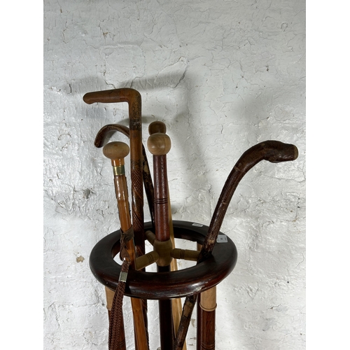 595 - An oak stick stand containing five walking canes