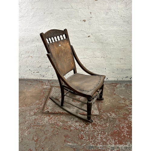 47 - An early 20th century beech rocking chair with spindle back and shell design