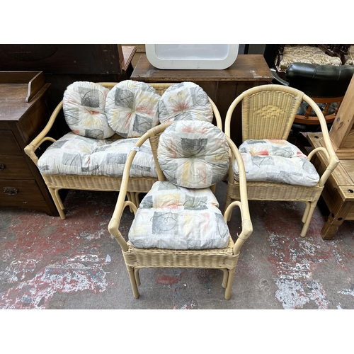 56 - A wicker and bamboo three piece conservatory suite comprising two seater sofa and two armchairs