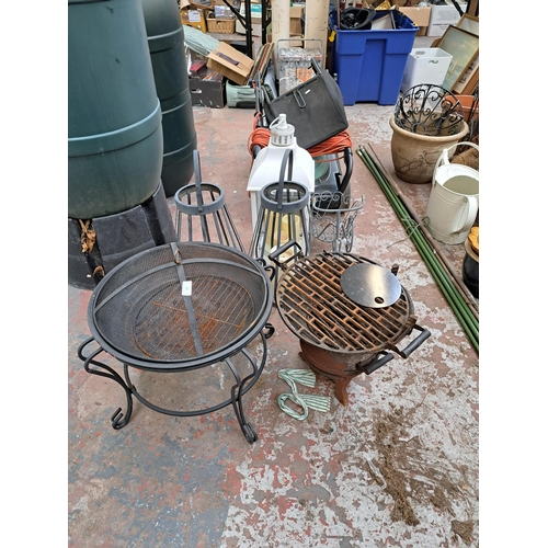 797 - A collection of garden items to include two cast and wrought iron fire pits, pair of wrought iron ha... 