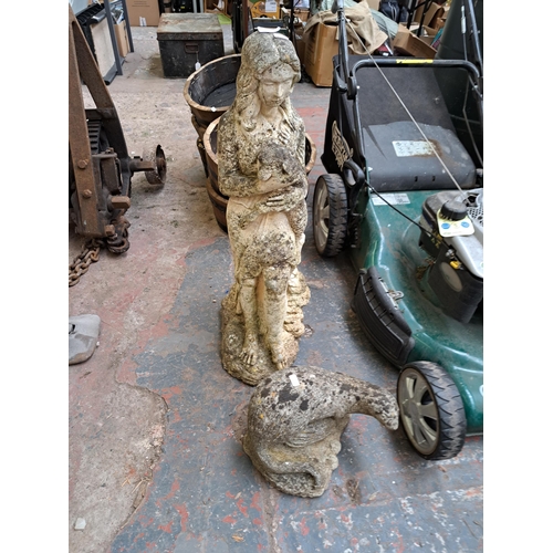 800 - Two cast stone garden ornaments, one statuette of a lady and lamb and one otter figurine