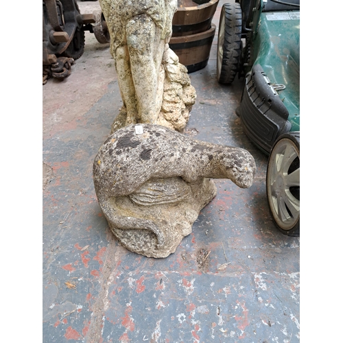 800 - Two cast stone garden ornaments, one statuette of a lady and lamb and one otter figurine