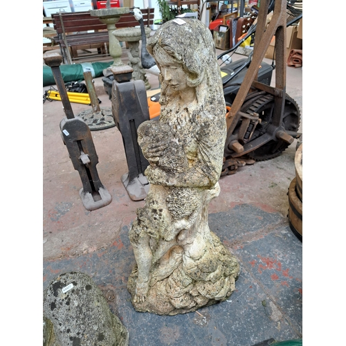 800 - Two cast stone garden ornaments, one statuette of a lady and lamb and one otter figurine