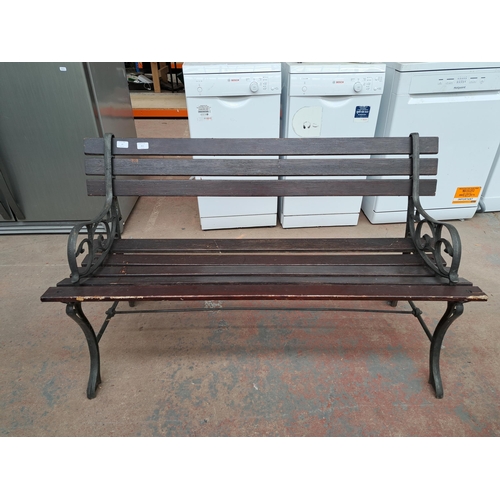 811 - A cast iron and wooden slatted garden bench