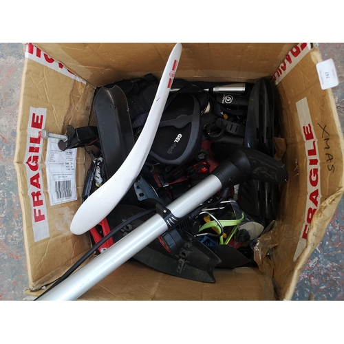 747 - Two boxes containing cycling equipment to include helmets, mud guards, pumps etc.