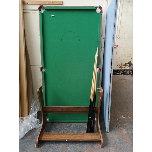 749 - A Hy-Pro International Ltd 6ft folding snooker table with four cues