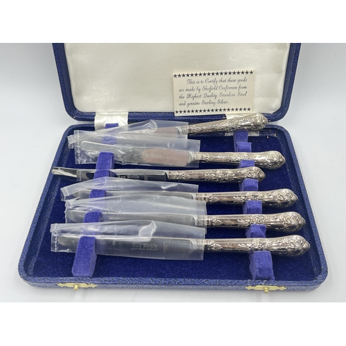 2302A - A cased set of six stainless steel butter knives with hallmarked sterling silver handles