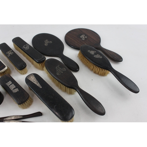 537 - A collection of antique ebony vanity items with hallmarked sterling silver detailing