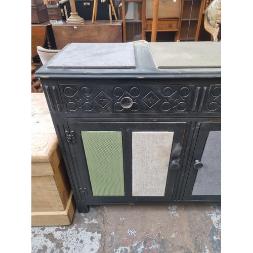 114 - A black painted and fabric upholstered sideboard