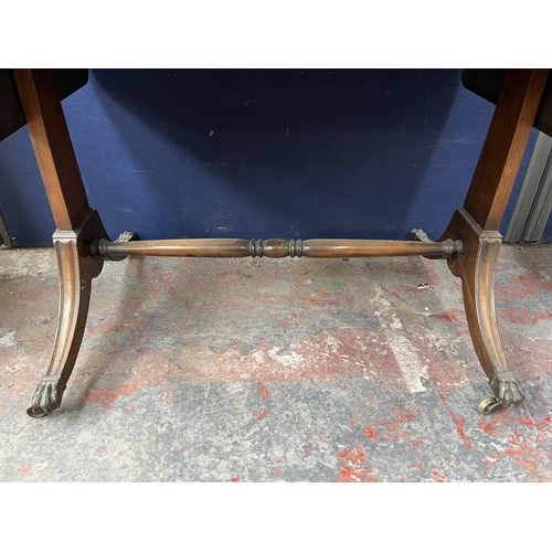 194 - An early 20th century Regency style walnut and mahogany crossbanded two drawer sofa table with brass... 