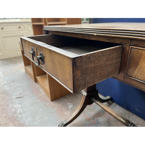 194 - An early 20th century Regency style walnut and mahogany crossbanded two drawer sofa table with brass... 