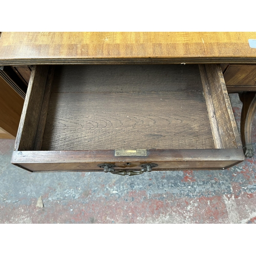 194 - An early 20th century Regency style walnut and mahogany crossbanded two drawer sofa table with brass... 