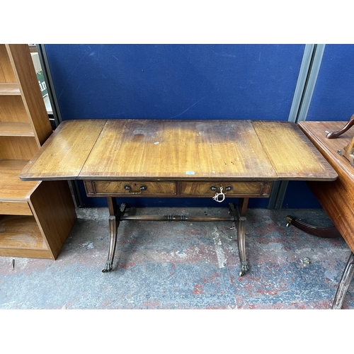 194 - An early 20th century Regency style walnut and mahogany crossbanded two drawer sofa table with brass... 