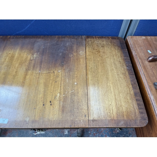 194 - An early 20th century Regency style walnut and mahogany crossbanded two drawer sofa table with brass... 