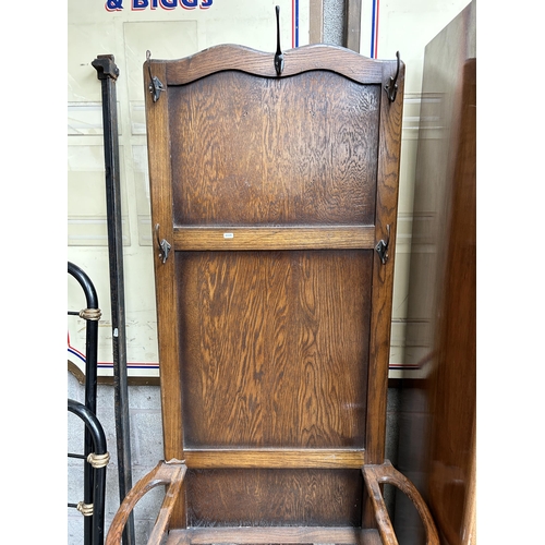 13 - An early 20th century oak hall stand with lidded seat and five coat hooks - approx. 184cm high x 79c... 