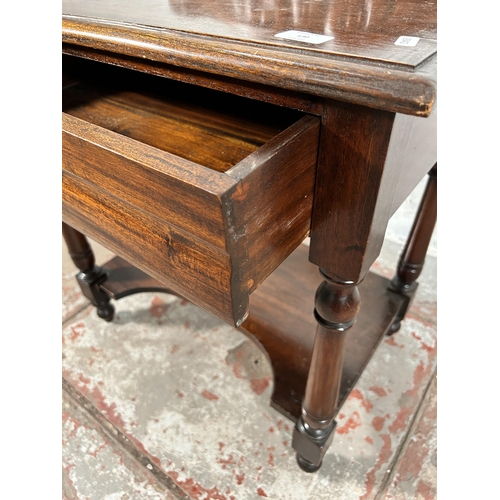 130 - A Victorian style carved mahogany two tier single drawer side table