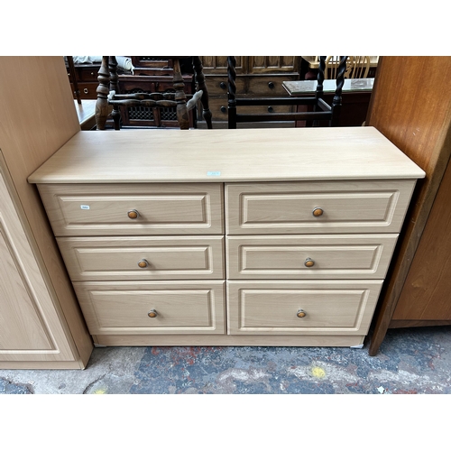 174 - A modern beech effect five piece bedroom suite comprising three chests of drawers and two double war... 