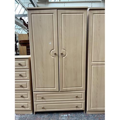 174 - A modern beech effect five piece bedroom suite comprising three chests of drawers and two double war... 