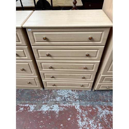 174 - A modern beech effect five piece bedroom suite comprising three chests of drawers and two double war... 