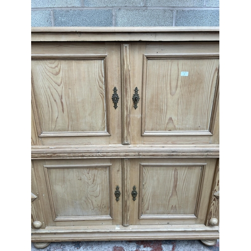 2 - A pine four door housekeeper's cupboard - approx. 144cm high x 55cm wide x 134cm deep