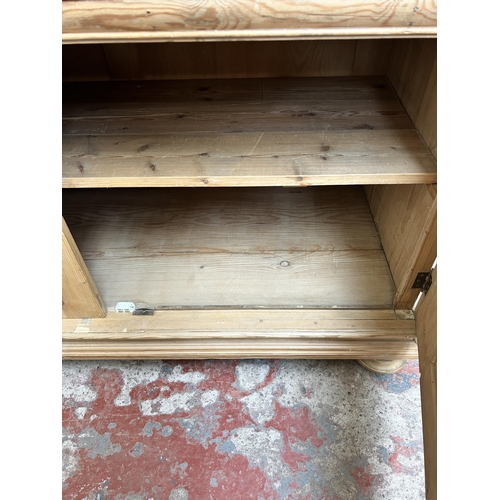 2 - A pine four door housekeeper's cupboard - approx. 144cm high x 55cm wide x 134cm deep