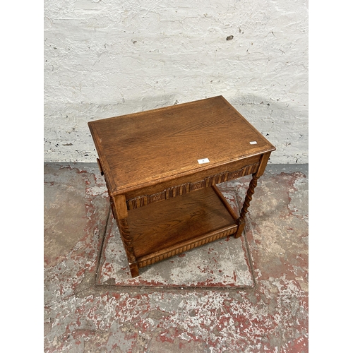 74 - A carved oak two tier side table on barley twist supports