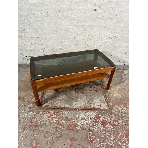 76 - A teak and smoked glass rectangular two tier coffee table