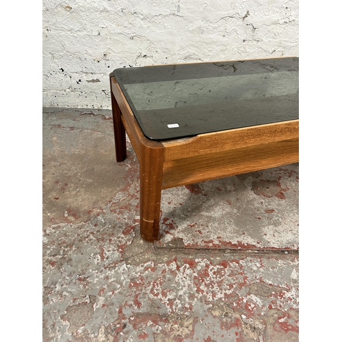 76 - A teak and smoked glass rectangular two tier coffee table