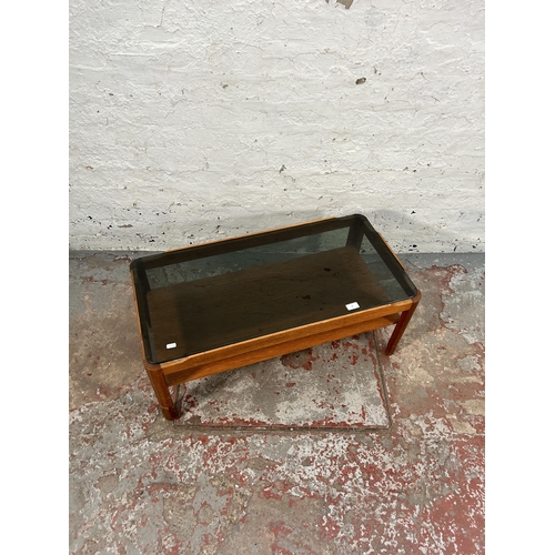 76 - A teak and smoked glass rectangular two tier coffee table