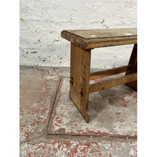 8 - A 19th century style oak farmhouse stool - approx. 44cm high x 60cm wide x 25cm deep