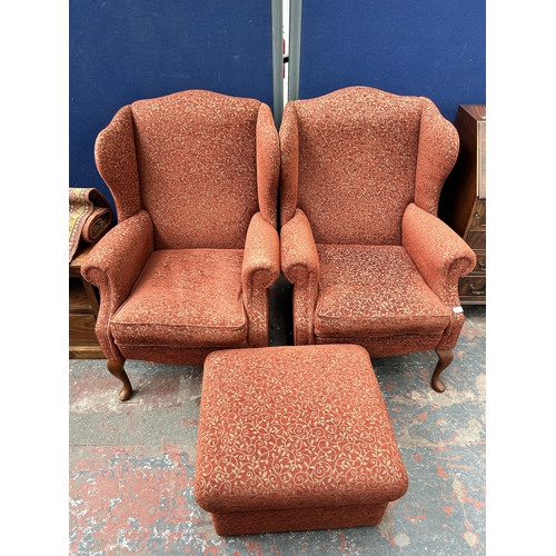 99 - A pair of Victorian style red floral fabric upholstered wingback armchairs with cabriole supports an... 